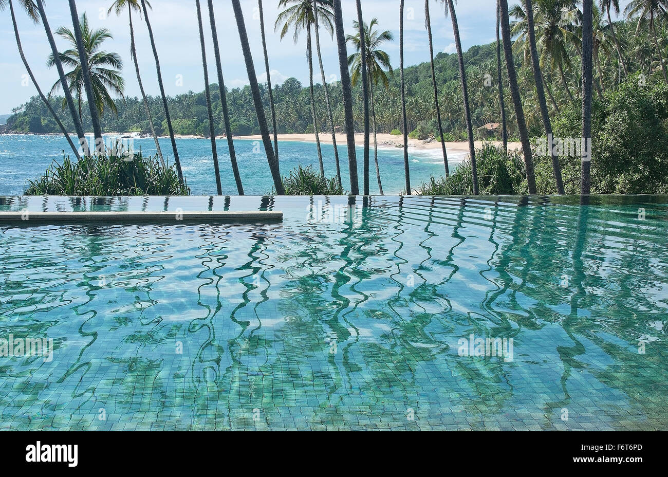 Ewigkeit Schwimmbad über Sandparadies Beach und Palm Bäumen in tropischen Landschaft. Stockfoto