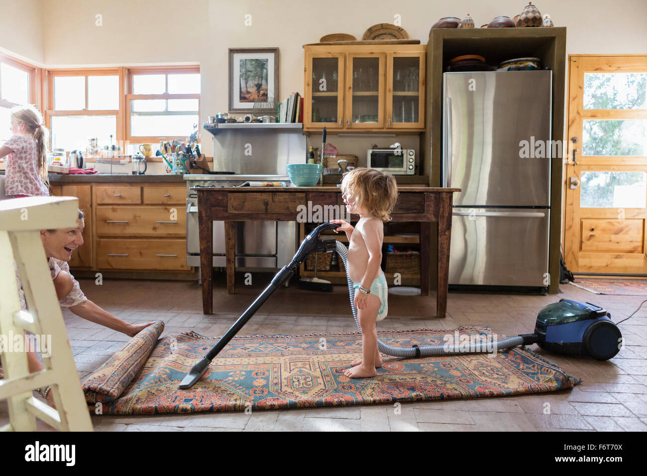 Kaukasische Bruder und Schwester Teppich saugen Stockfoto