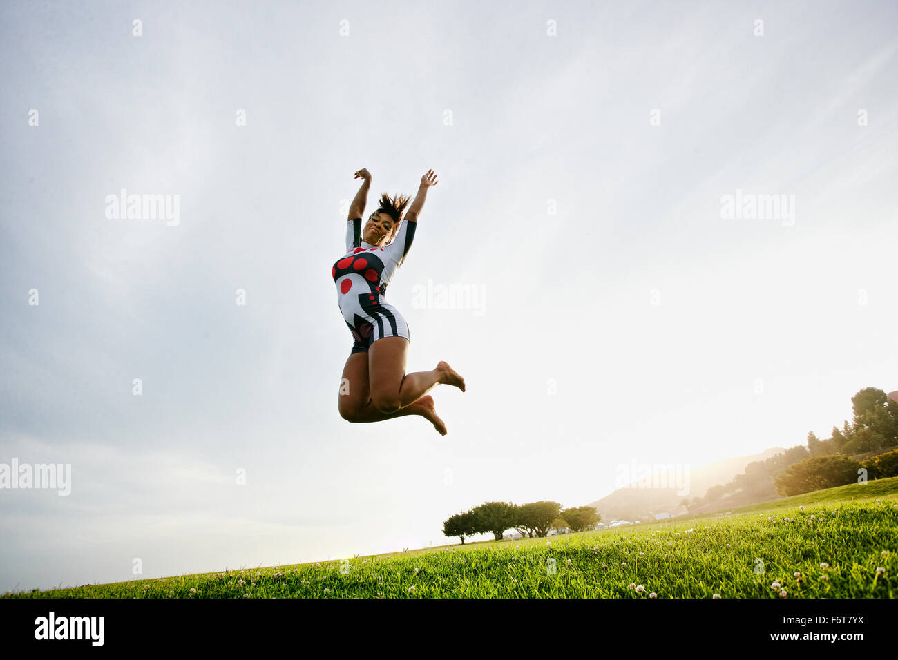 Schwarze Frau springen vor Freude im Feld Stockfoto