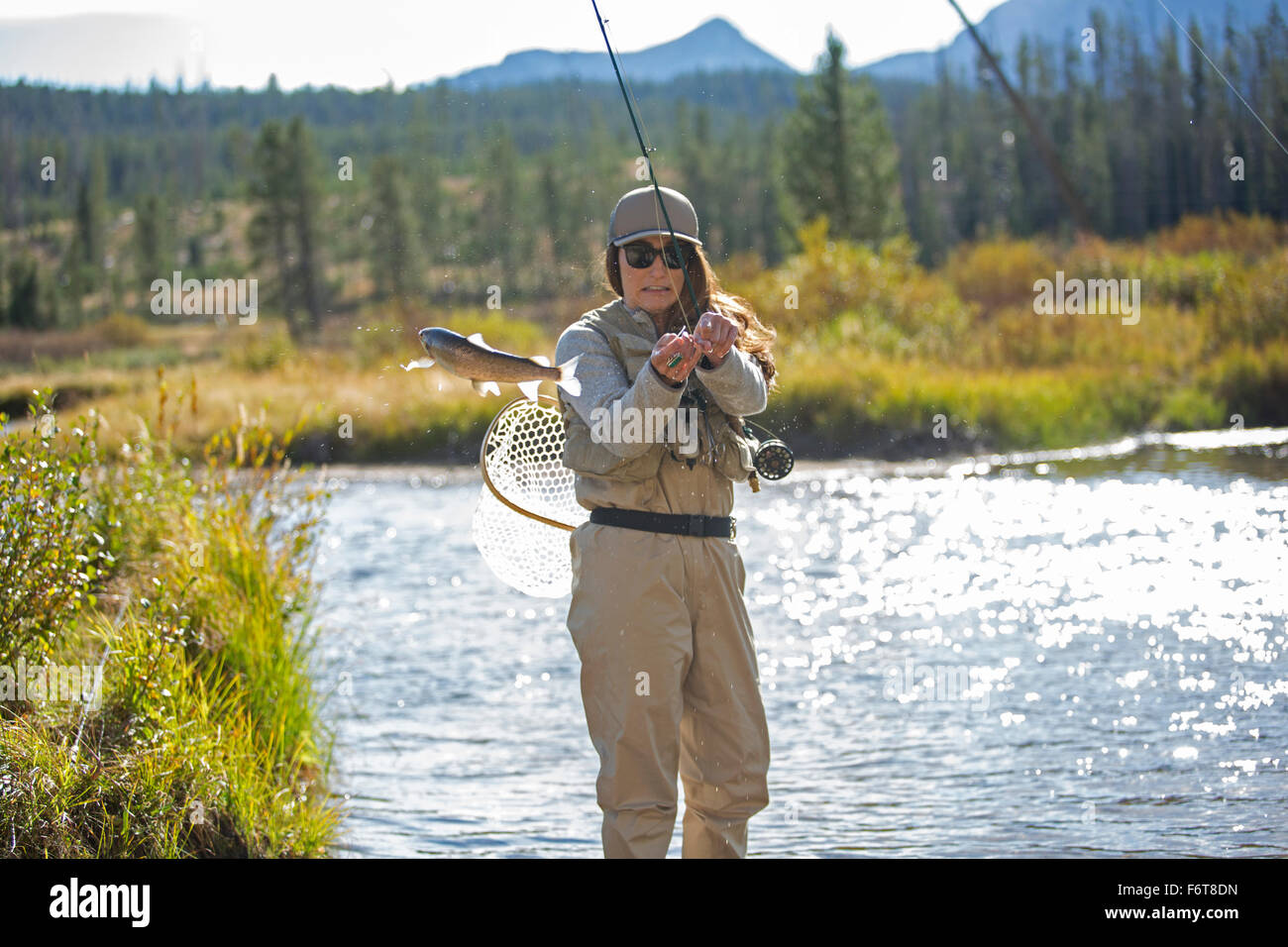 Kaukasische Frau im ländlichen Fluss angeln Stockfoto