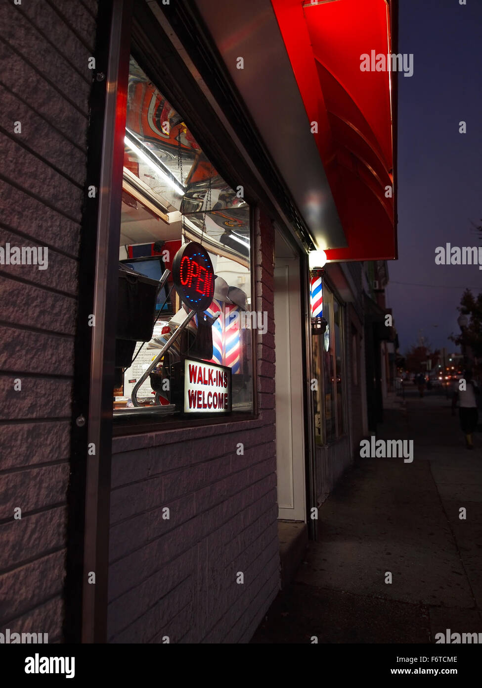 Traditionellen rote, weiße und blaue Barbershop Polen Leuchten auf einer städtischen Straße in der Abenddämmerung. Stockfoto