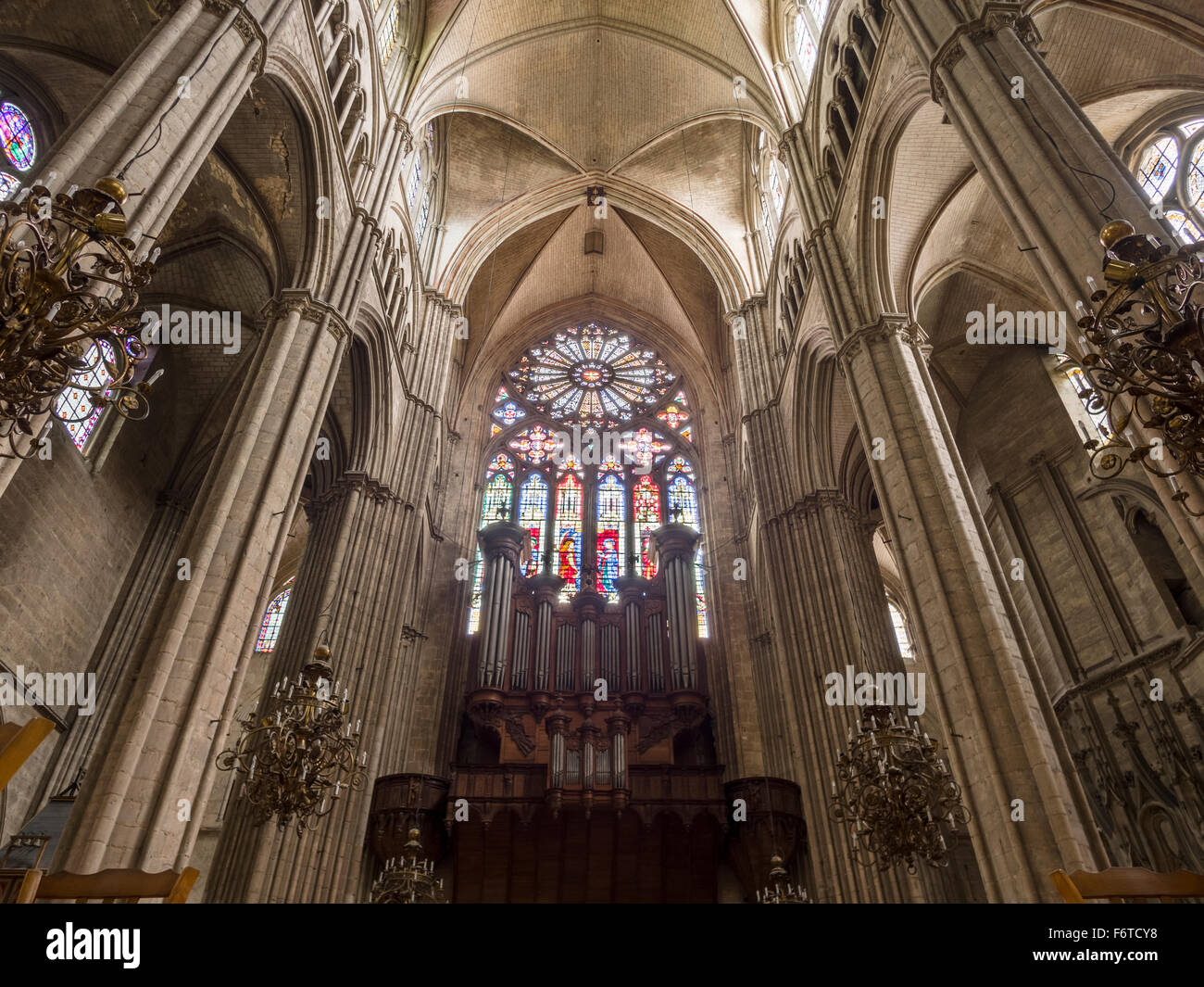 Heckscheibe und Orgel in der Kathedrale von Bourges. Die große Rosette leuchtet das dunkle Holz und Stahl von der Orgelpfeifen von hinten. Stockfoto