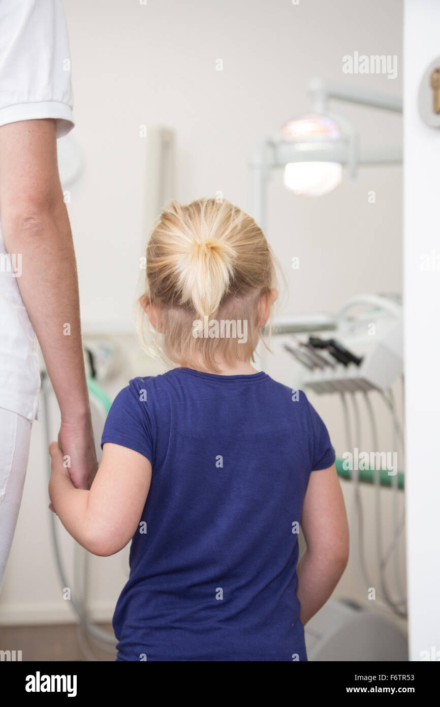 Zahnarzthelferin an Hand des Mädchens vor der Behandlung Stockfoto