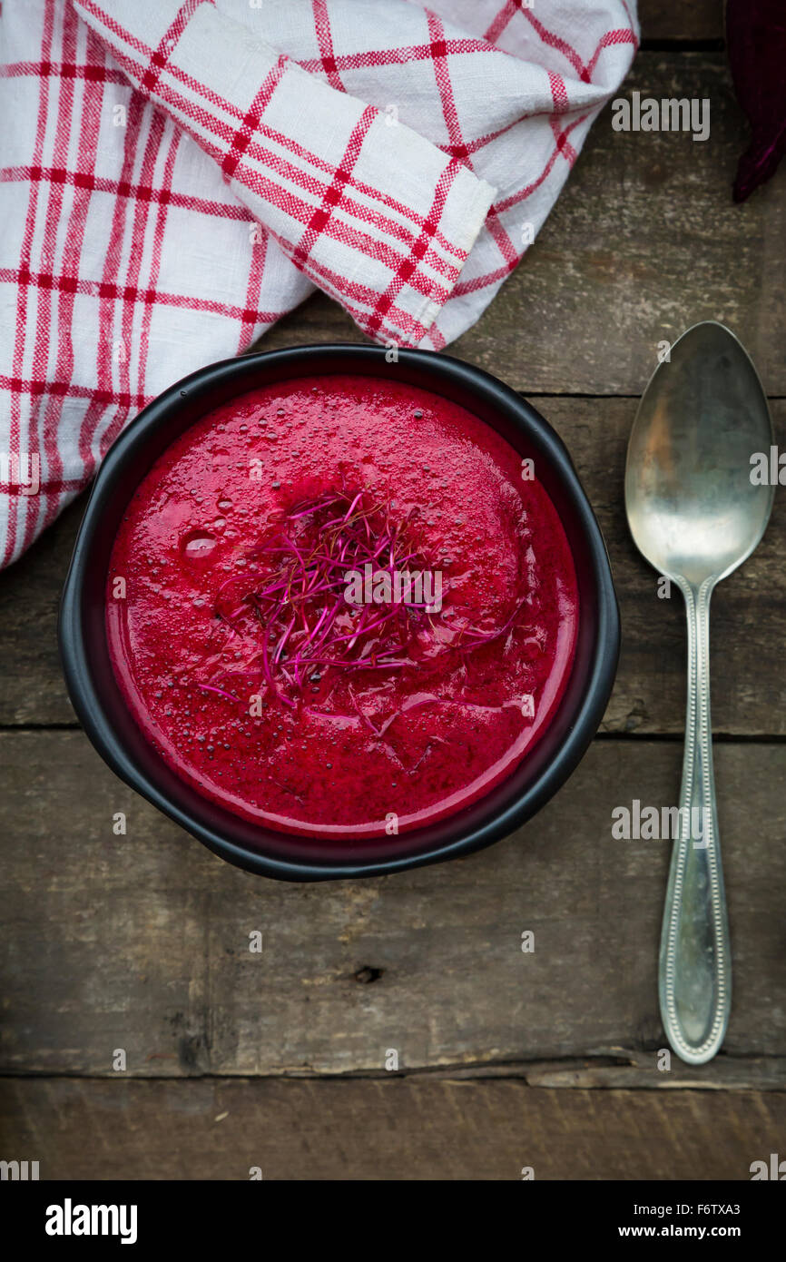 Rote Bete Suppe garniert mit rote Beete Sprossen auf dunklem Holz Stockfoto