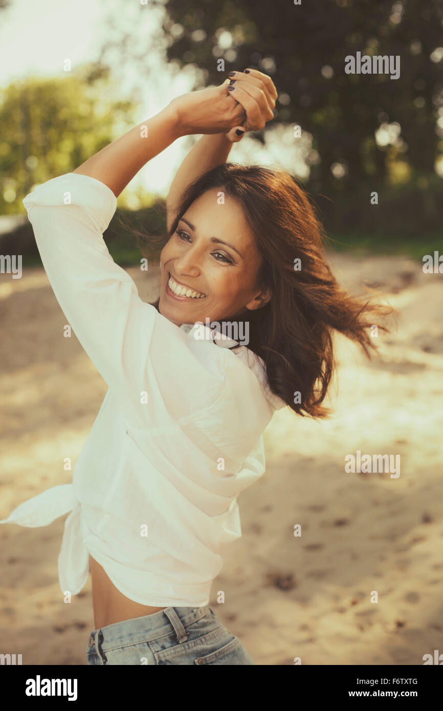 Porträt der glückliche Frau tanzen am Strand Stockfoto