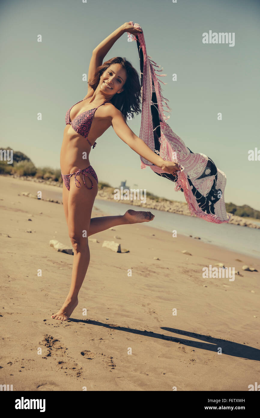 Deutschland, Köln, Porträt der lächelnde Frau mit Tuch tanzen am Strand Stockfoto