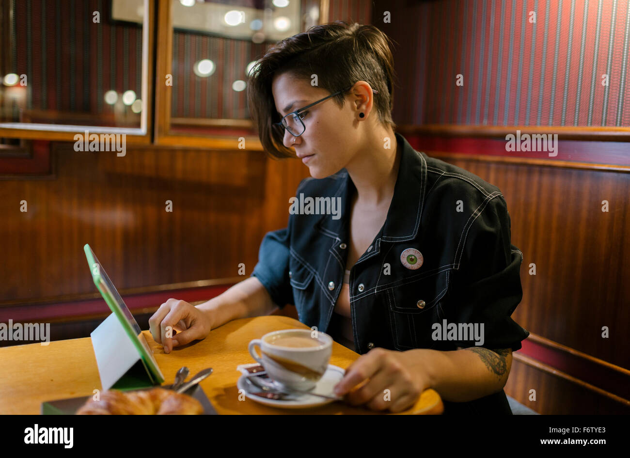Junge Frau sitzt in einem Café mit digital-Tablette Stockfoto