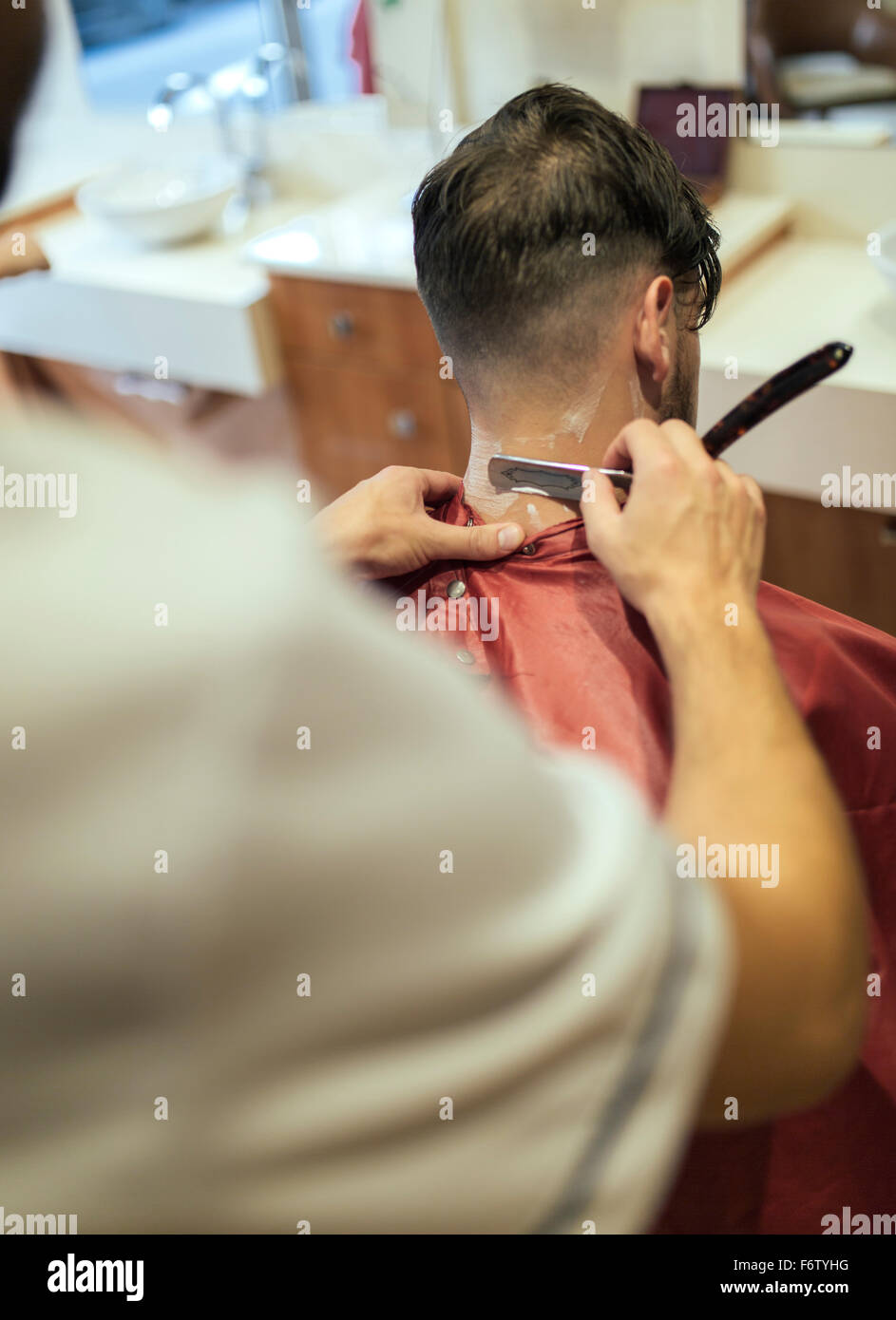 Barbier rasieren Hals eines Kunden Stockfoto
