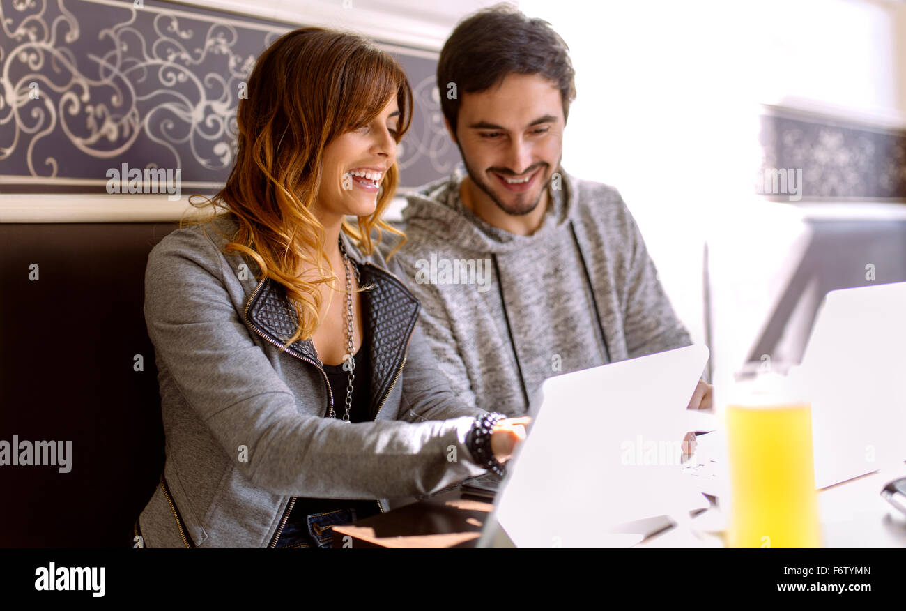 Lächelnde junge Paar mit digital-Tablette in einer Kneipe Stockfoto