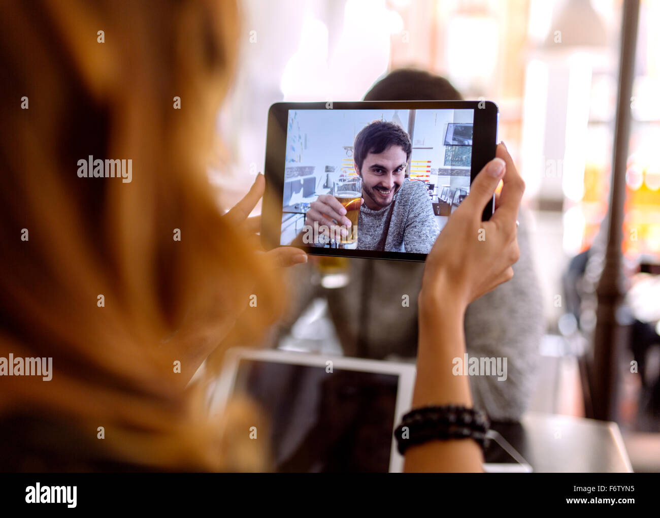 Junge Frau unter Fotografie ihres Freundes mit digital-Tablette Stockfoto