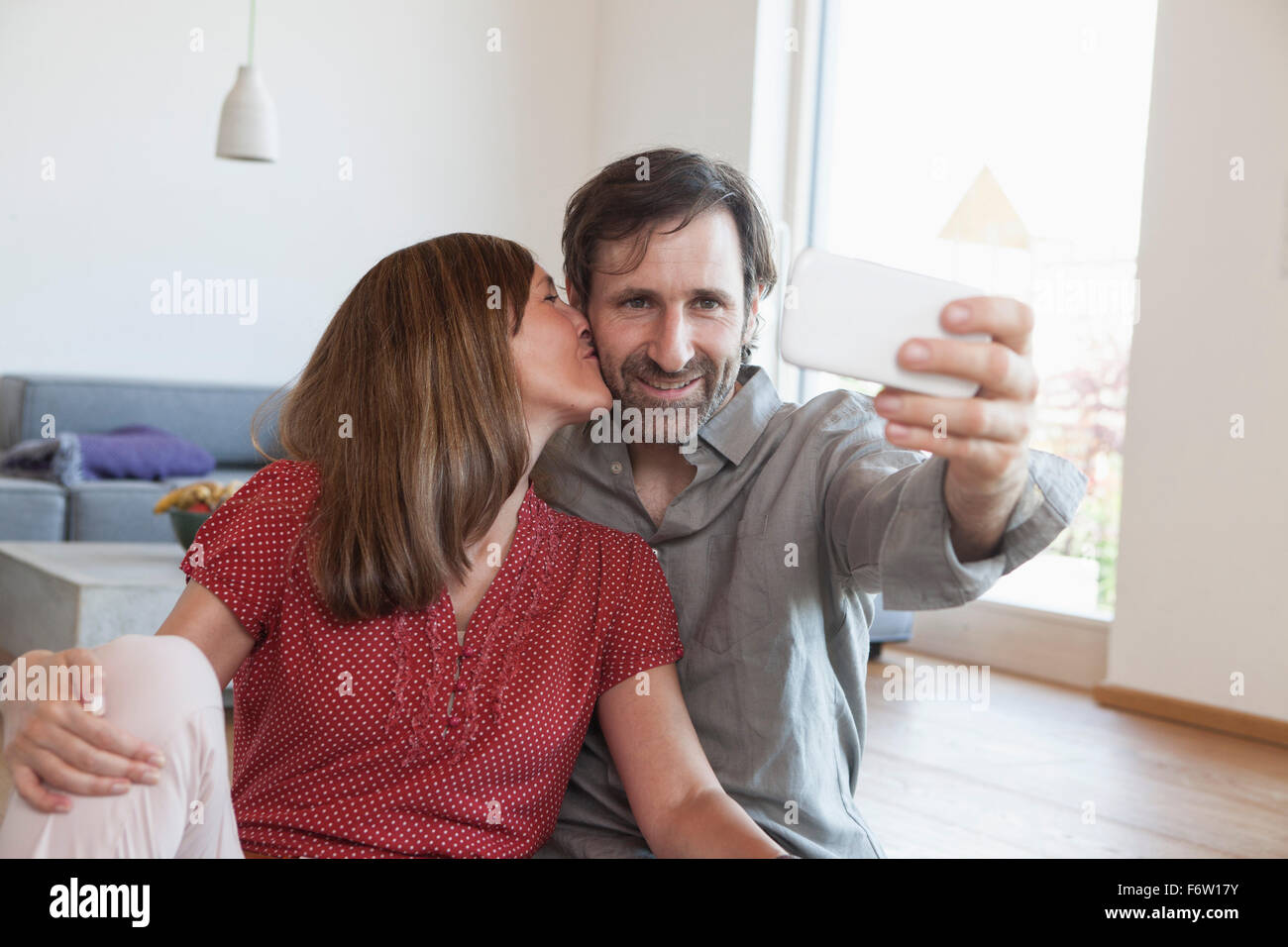 Älteres Paar am Boden unter Selfie mit Smartphone Stockfoto