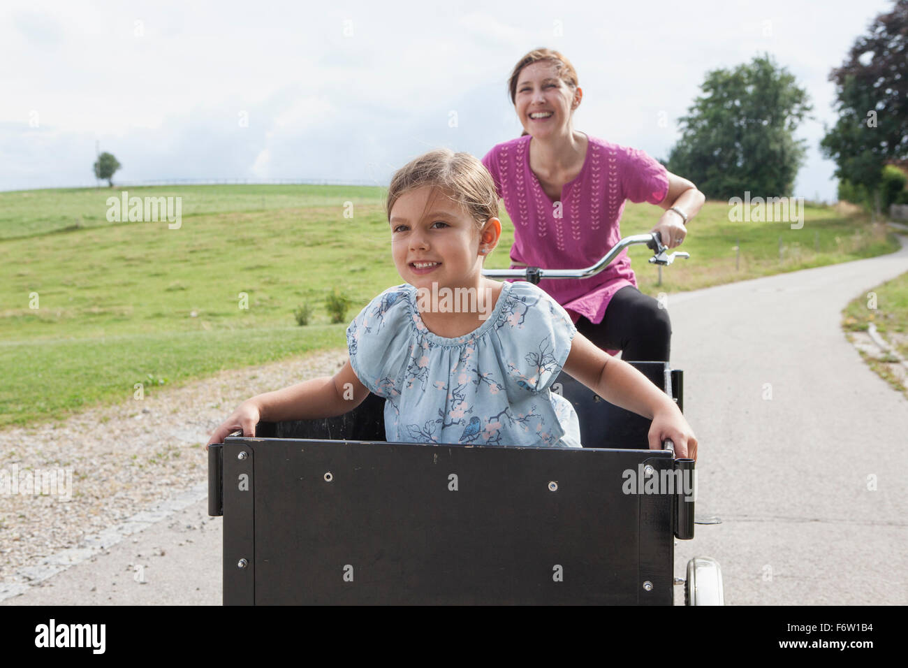 Mutter Reiten Fahrrad mit Tochter Trailer Stockfoto