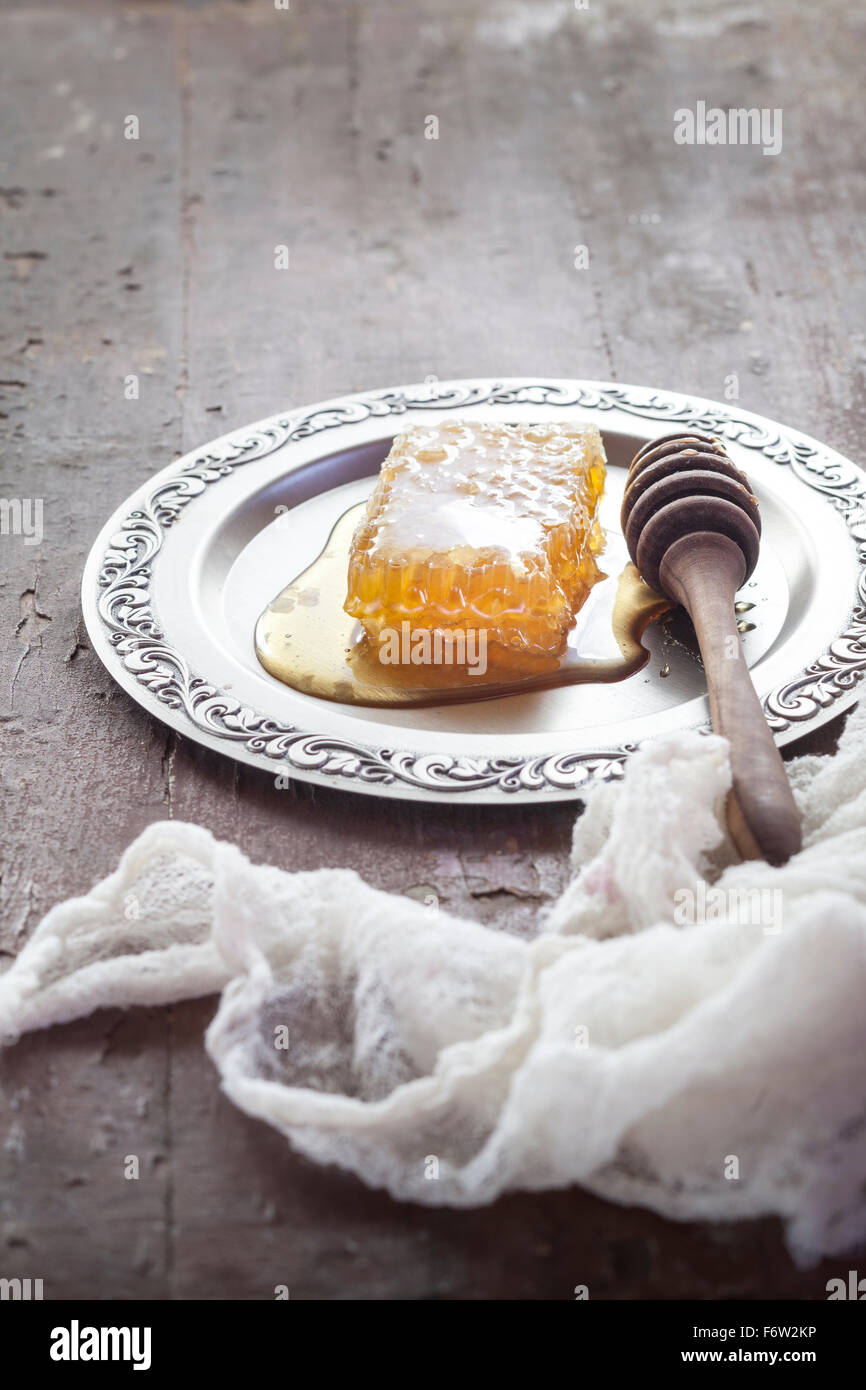 Waben Sie mit Honig und Honig-Löffel auf Weißblech Stockfoto