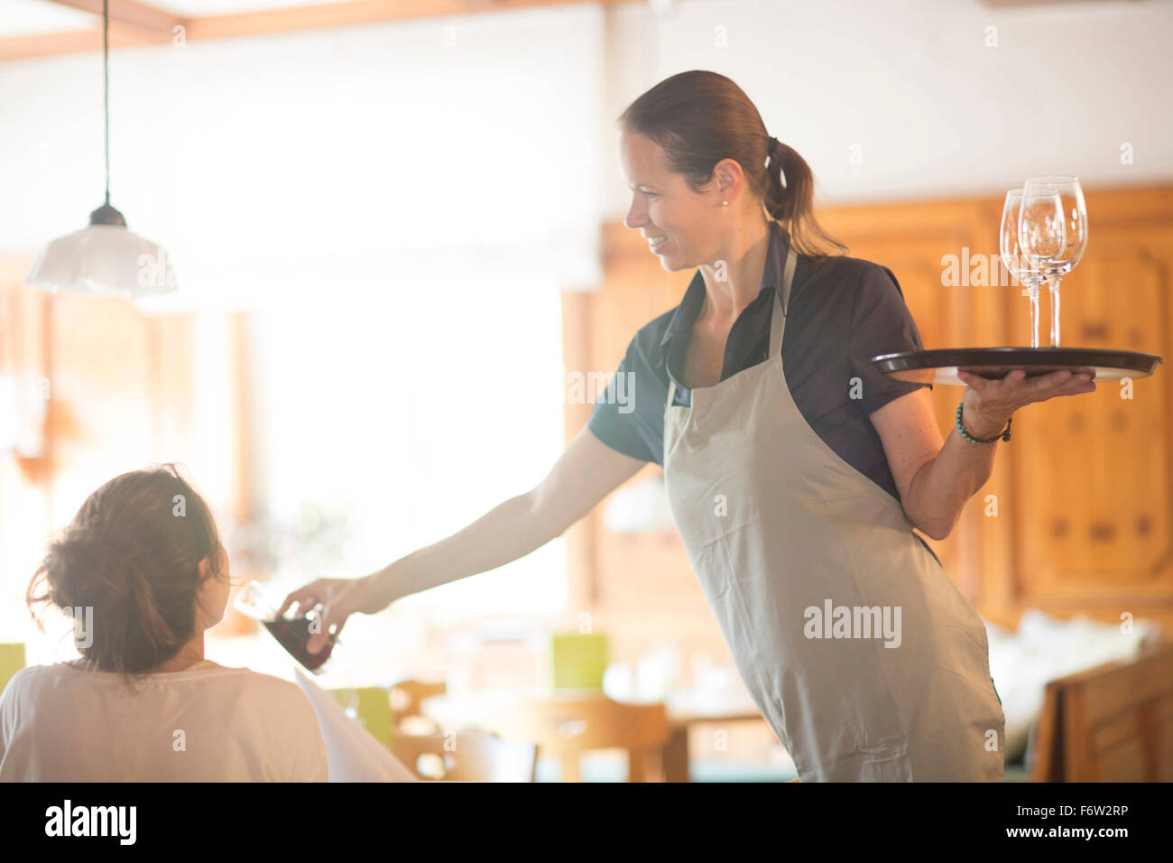 Kellnerin serviert Wein im restaurant Stockfoto