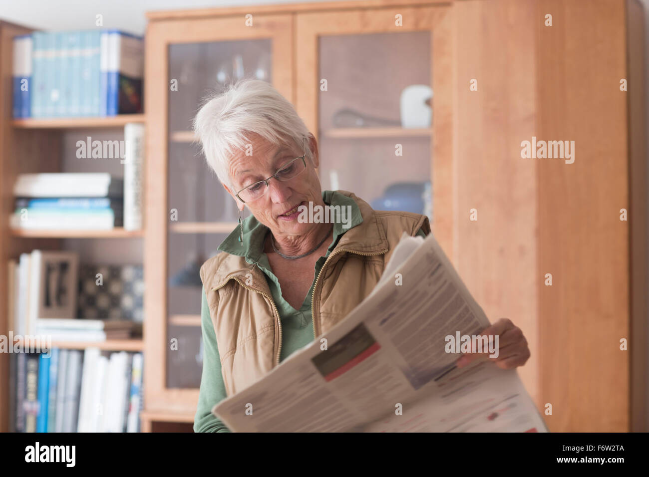 Porträt von weißen Haaren senior Frau liest Zeitung zu Hause Stockfoto