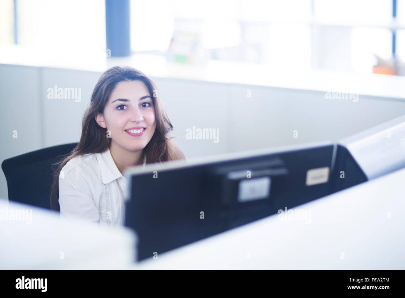 Porträt der lächelnde junge Frau an ihrem Arbeitsplatz Stockfoto
