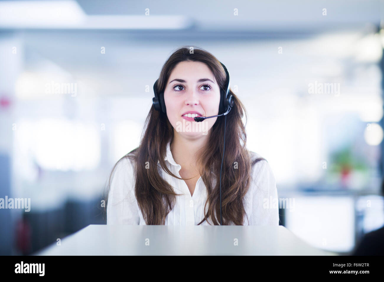 Porträt der jungen Frau mit Kopfhörer in einem Büro Stockfoto