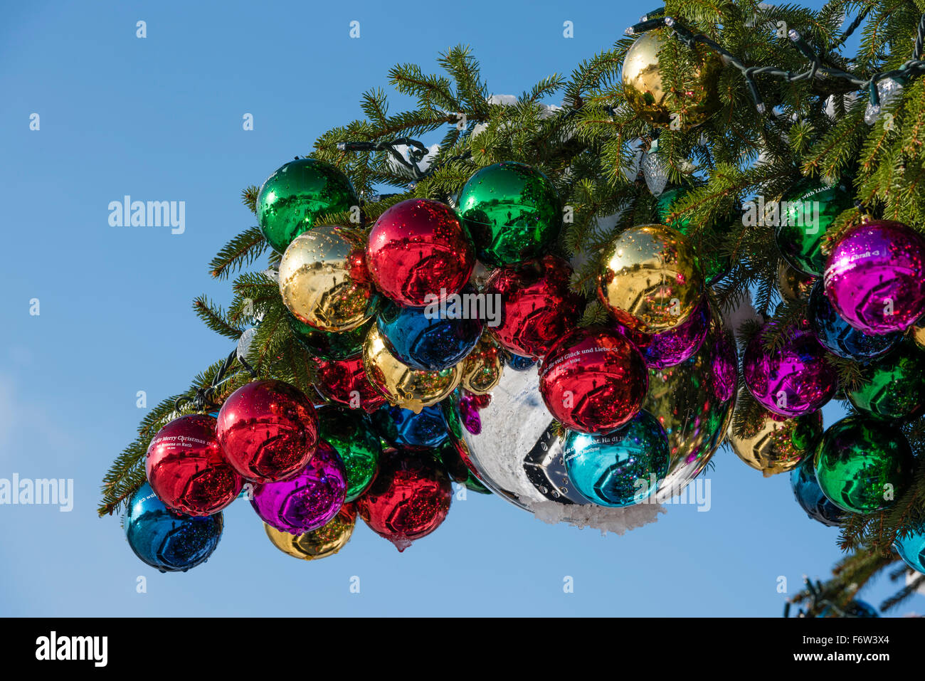 Bunte Weihnachtskugel Ornamente auf einen riesigen Weihnachtsbaum auf Saechselaeutenplatz, außerhalb Opernhaus Zürich, Schweiz. Stockfoto