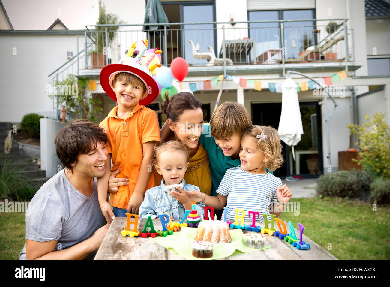 Glückliche Familie mit einer Kinder Geburtstagsparty im Garten
