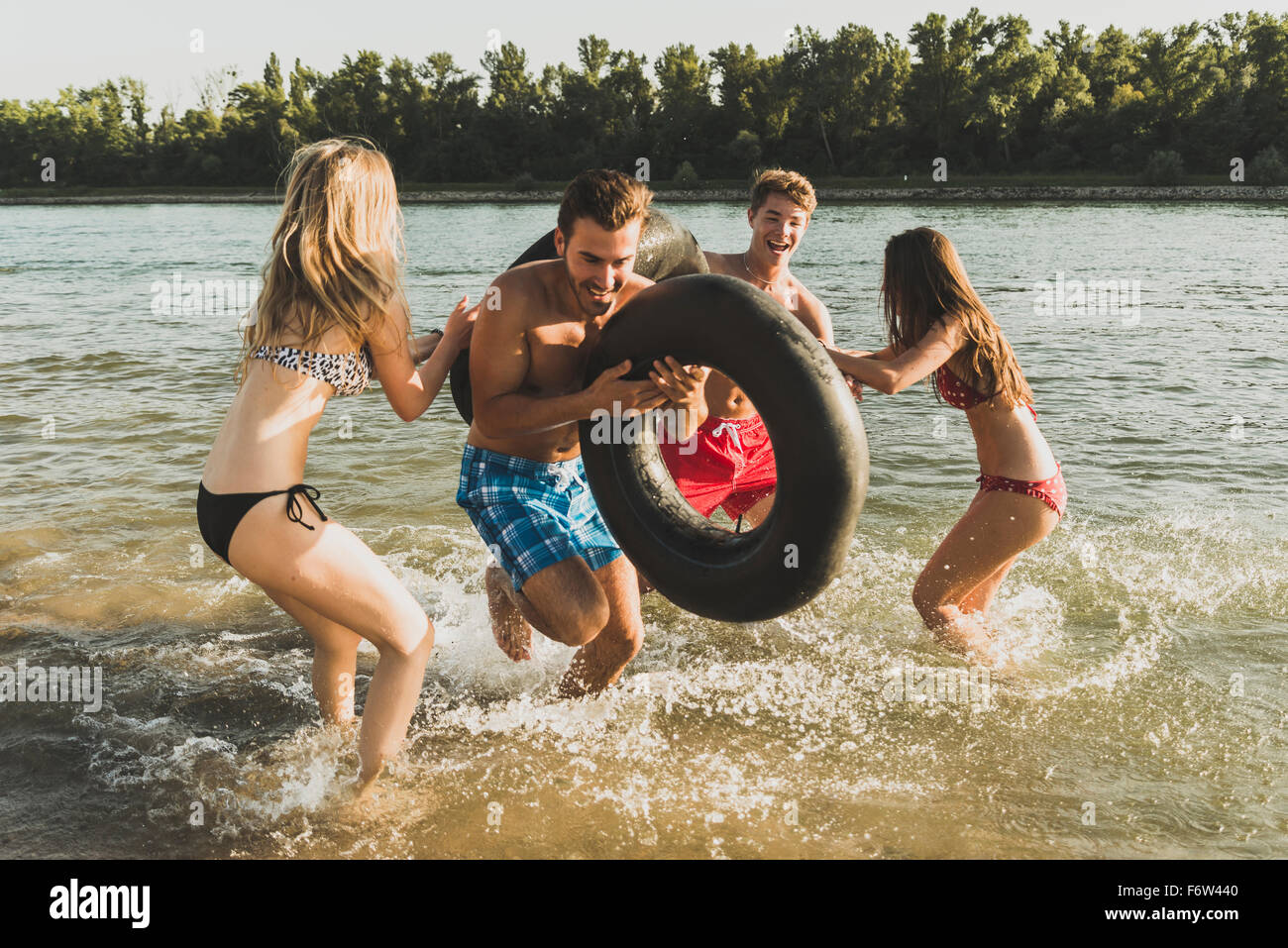 Verspielte Freunde mit Schläuche im Fluss Stockfoto