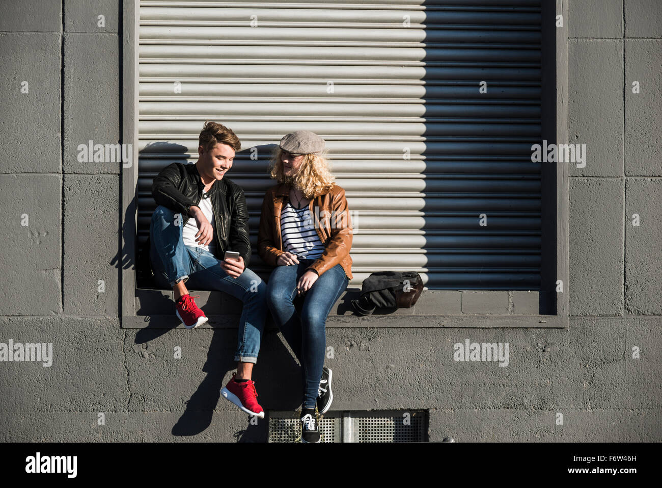 Entspannte junges Paar mit Handy im freien Stockfoto