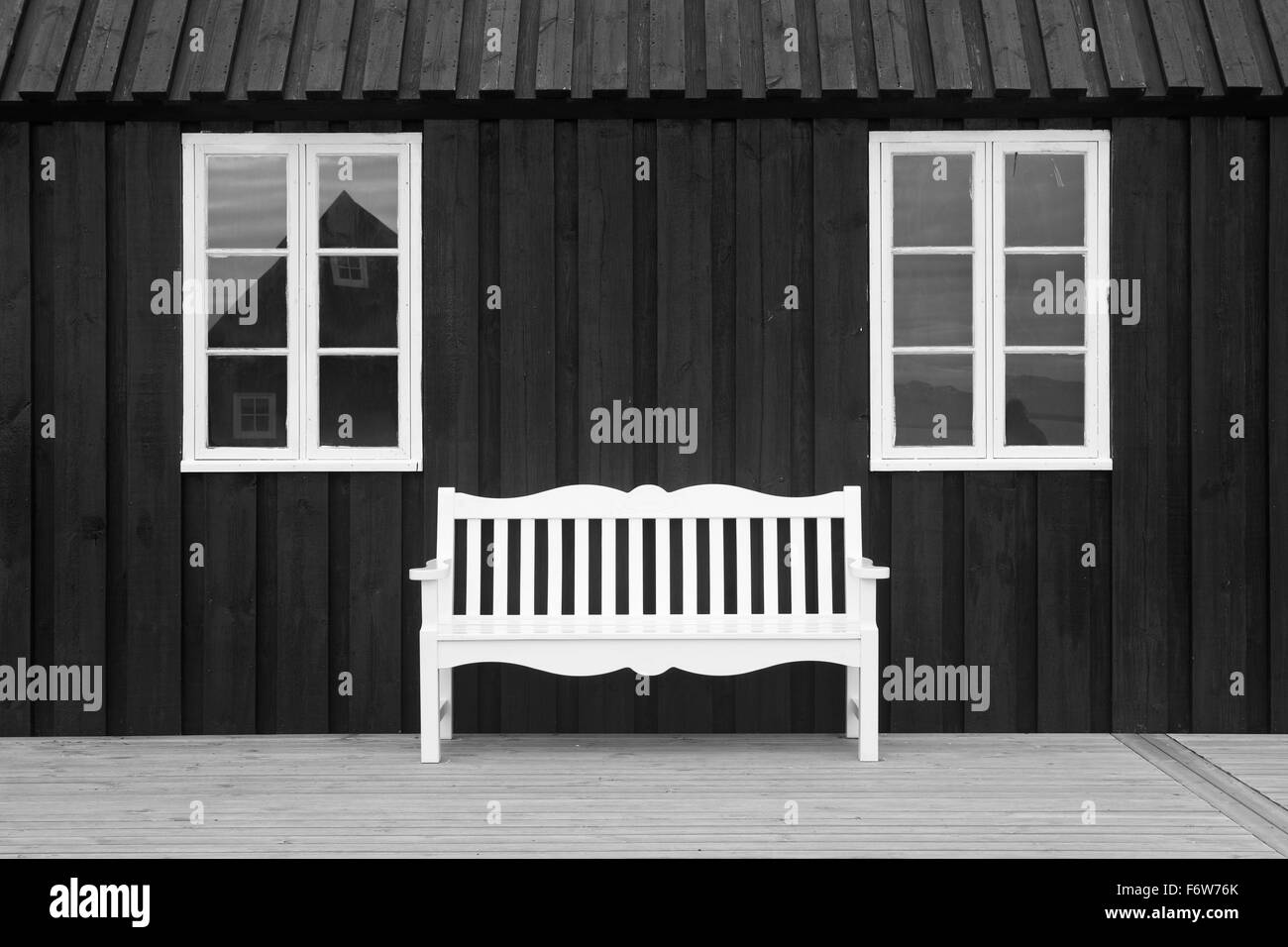 Schwarzes Holz Lager mit weißen Fenstern und Sitz Stockfoto