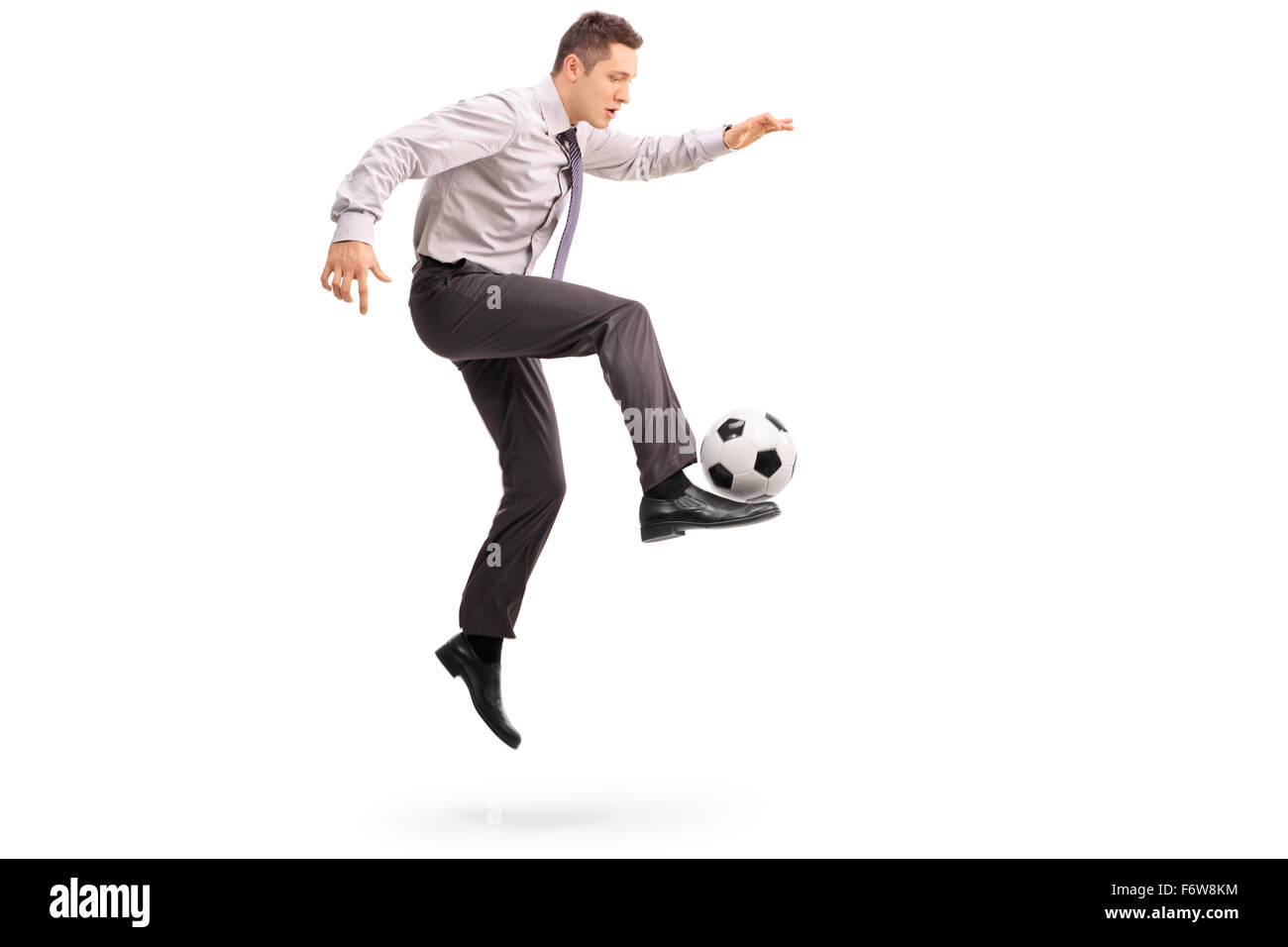 Voller Länge Profil Schuss ein junger Geschäftsmann Fußball spielen schoss in der Luft isoliert auf weißem Hintergrund Stockfoto