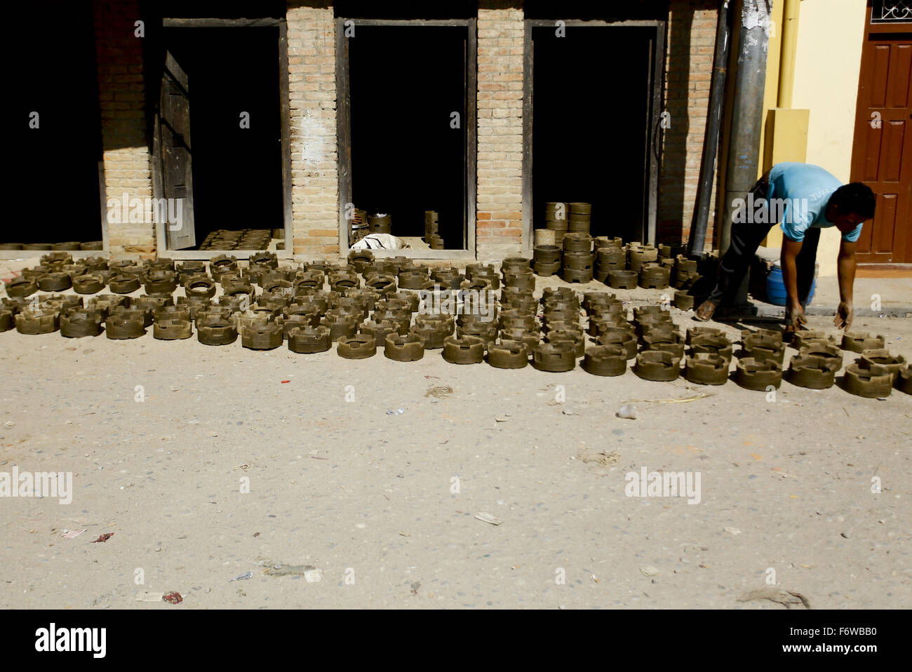 Bhaktapur, Nepal. 20. November 2015. Ein nepalesischer Mann trocknet elektrische Heizungen aus Lehm im Sonnenlicht in Bhaktapur, Nepal, 20. November 2015 gemacht. Aufgrund des akuten Mangels an Flüssiggas da Indien inoffizielle Blockade vor etwa zwei Monaten verhängt suchen Nepalesen nach Alternativen, dass sie ihr normales Leben führen können. © Pratap Thapa/Xinhua/Alamy Live-Nachrichten Stockfoto