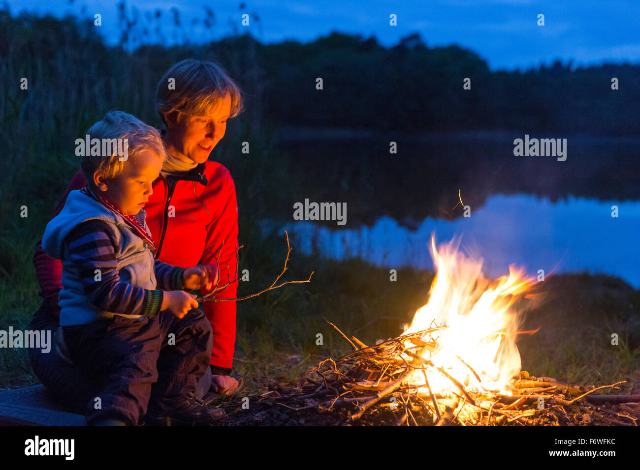 Mutter und Sohn in der Nähe von 2 Jahren ein Lagerfeuer am Seeufer, in der Nähe von Blumenholz, Mecklenburg-Western Pomerania, Deutschland Stockfoto