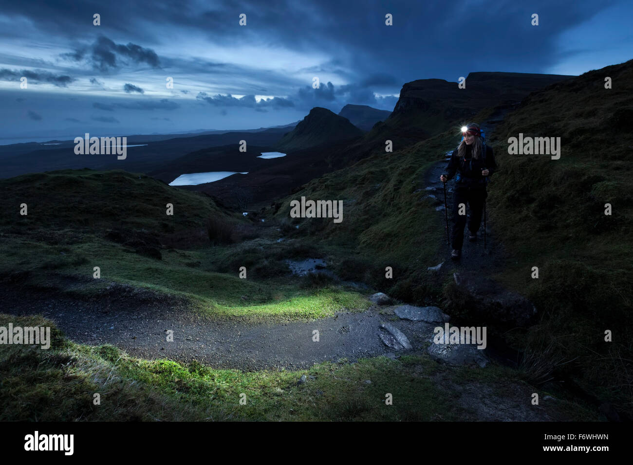 Junge Frau mit Stirnlampe Wandern in Twilight, Quiraing, Trotternish Halbinsel Isle Of Skye, Schottland, Vereinigtes Königreich Stockfoto
