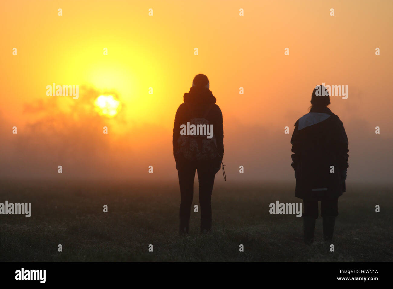 Mädchen beobachten den Sonnenaufgang auf der Aue Stockfoto