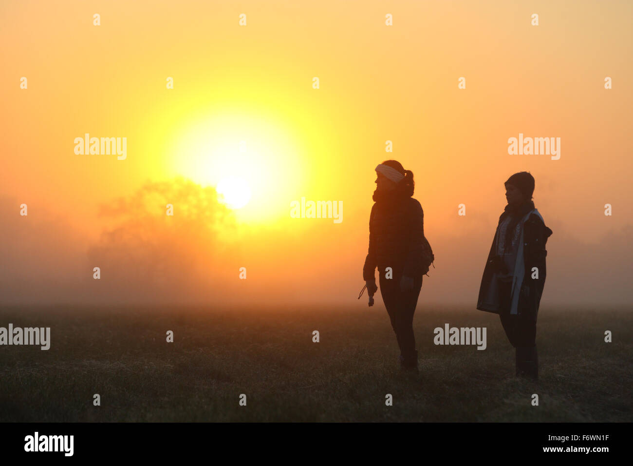 Mädchen beobachten den Sonnenaufgang auf der Aue Stockfoto