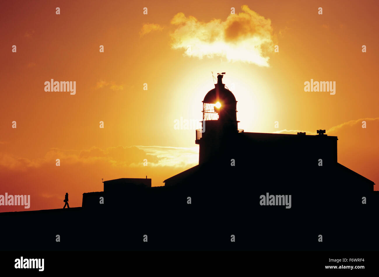 Mann und Stoner Head Lighthouse im Sonnenuntergang, Stoner, Hochland, Großbritannien Stockfoto