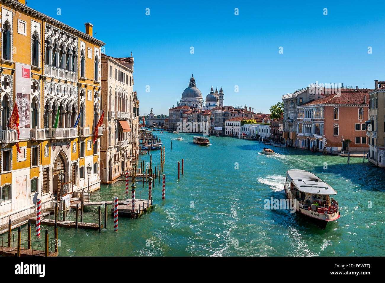 Atemberaubende Aussicht der Boote auf dem Canal Grande in Venedig mit Santa Maria Della Salute im Hintergrund. Stockfoto