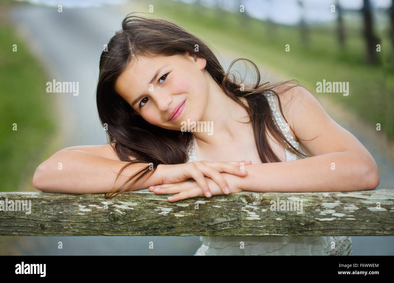 Eine schöne junge Landmädchen stützte sich auf einem Hof Stockfoto