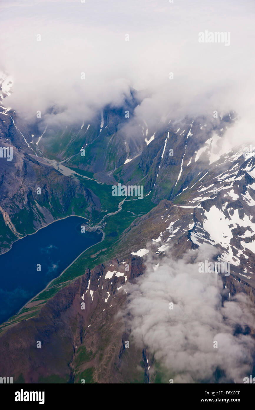 Luftaufnahme der Wolken, die die Gipfel verdunkeln, mit Einem üppigen Green Valley und einem im Vordergrund sichtbaren See, Aleutian Range, Alaska Peninsula, Südwest A... Stockfoto