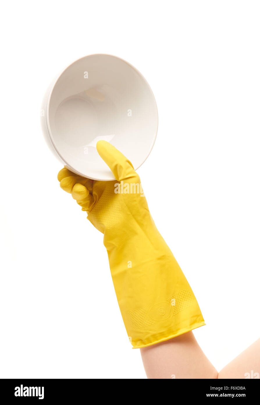 Nahaufnahme des weiblichen Hand in gelben schützende Gummihandschuh mit sauberen weißen Schüssel vor weißem Hintergrund. Stockfoto