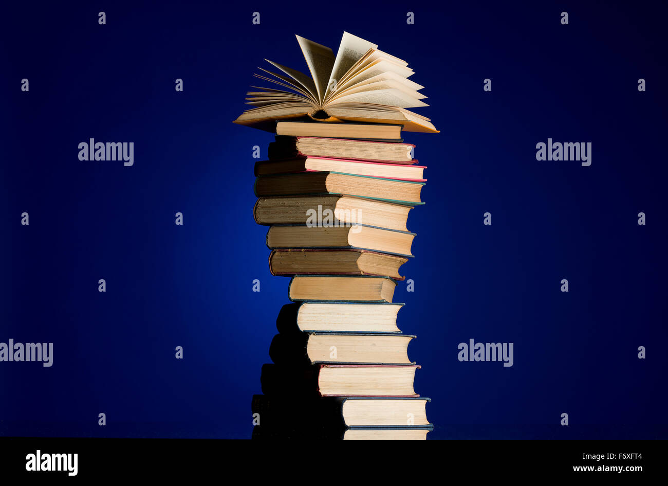 Stapel alter Bücher in eine Spirale drehen. Offenes Buch an die Spitze des Haufens. Büchersammlung. Lesen Sie, Bildung Metapher. Stockfoto