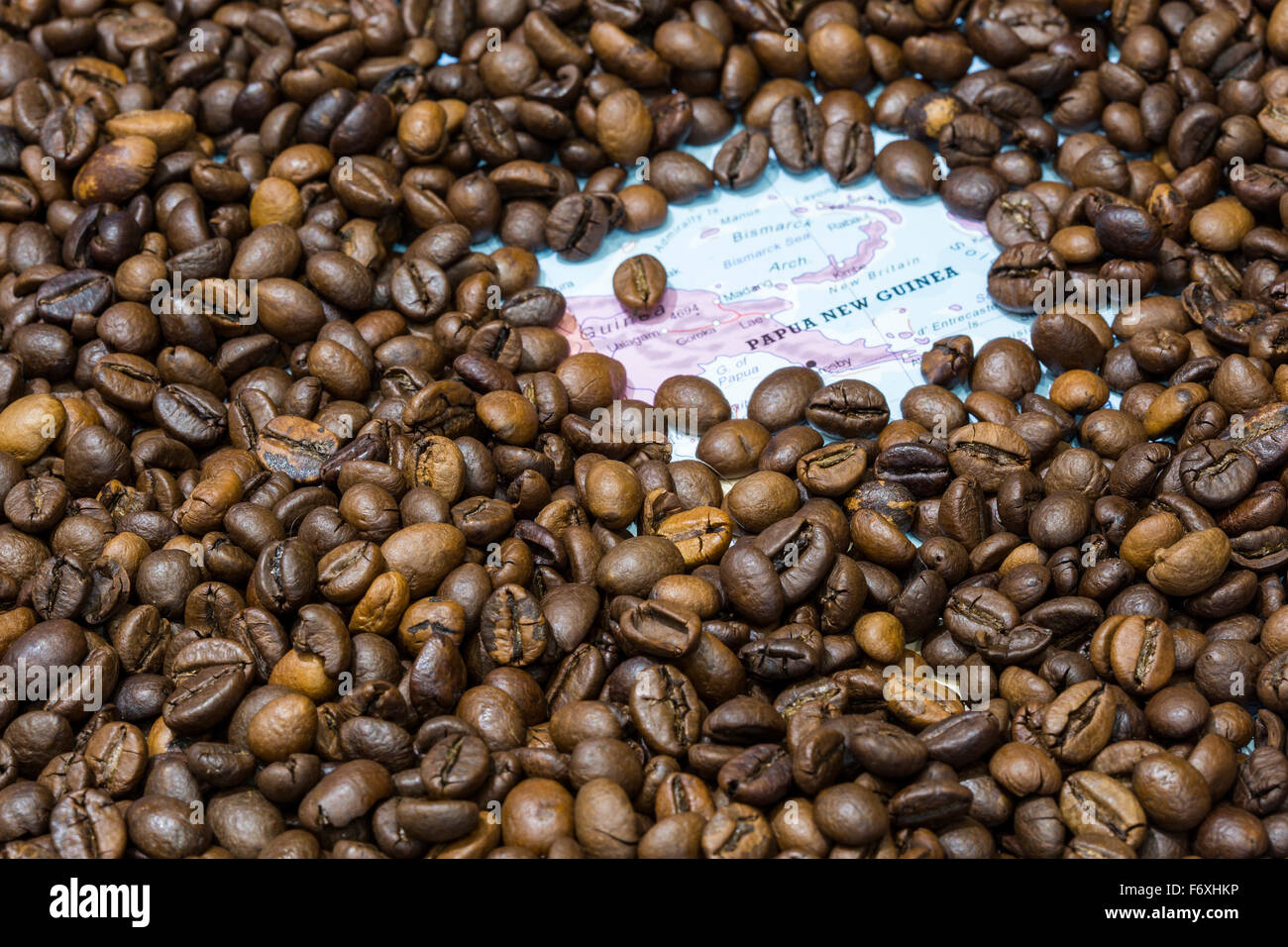 Landkarte von Papua New Guinea bedeckt von einem Hintergrund von gerösteten Kaffeebohnen. Diese Nation ist einer der wichtigsten Produzenten ein Stockfoto