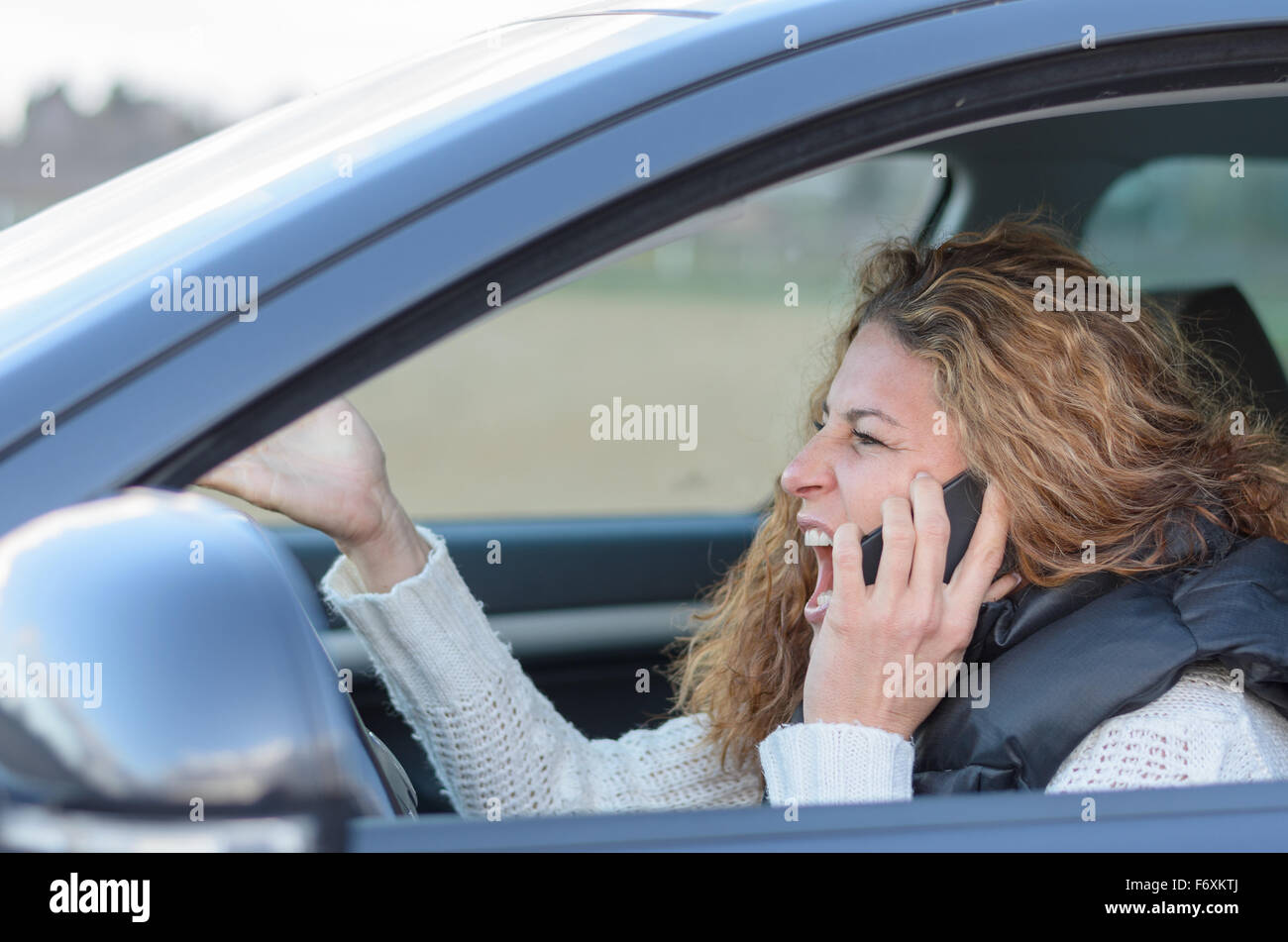 Frau ist ihr Auto sehr aggressiv und ein Gespräch Stockfoto