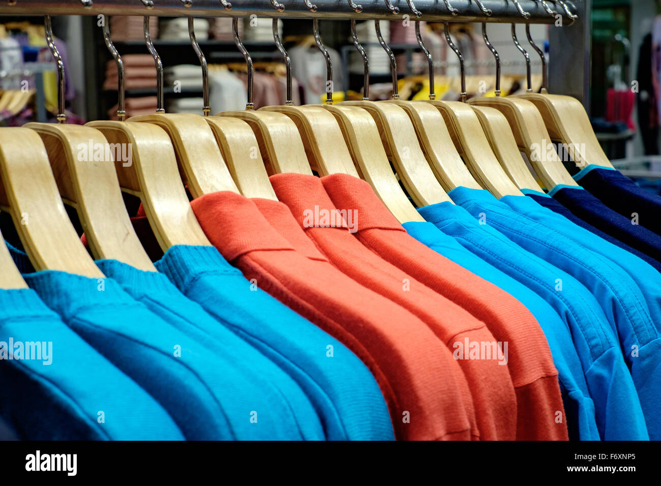 Modische Kleidung auf Bügeln im shop Stockfoto