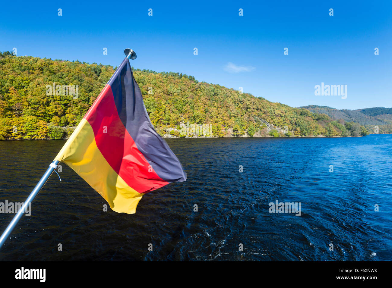 Deutsche Flagge auf einem Schiff auf See Rursee mit blauen Himmel und Sonne im Sommer. Stockfoto