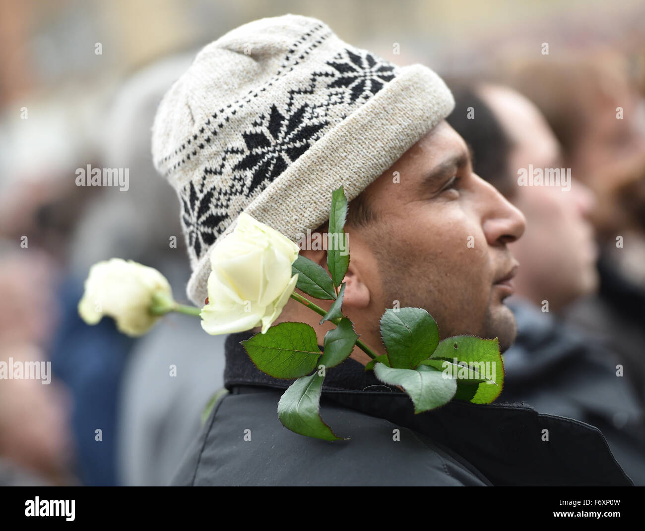 Hanau, Deutschland. 21. November 2015. Ein Mann mit weißen Rosen auf seine Jacke besucht eine Gedenk-Rallye für die Opfer der Terroranschläge Paris, auf dem Freiheitsplatz in Hanau, Deutschland, 21. November 2015 statt. Foto: ARNE DEDERT/Dpa/Alamy Live-Nachrichten Stockfoto