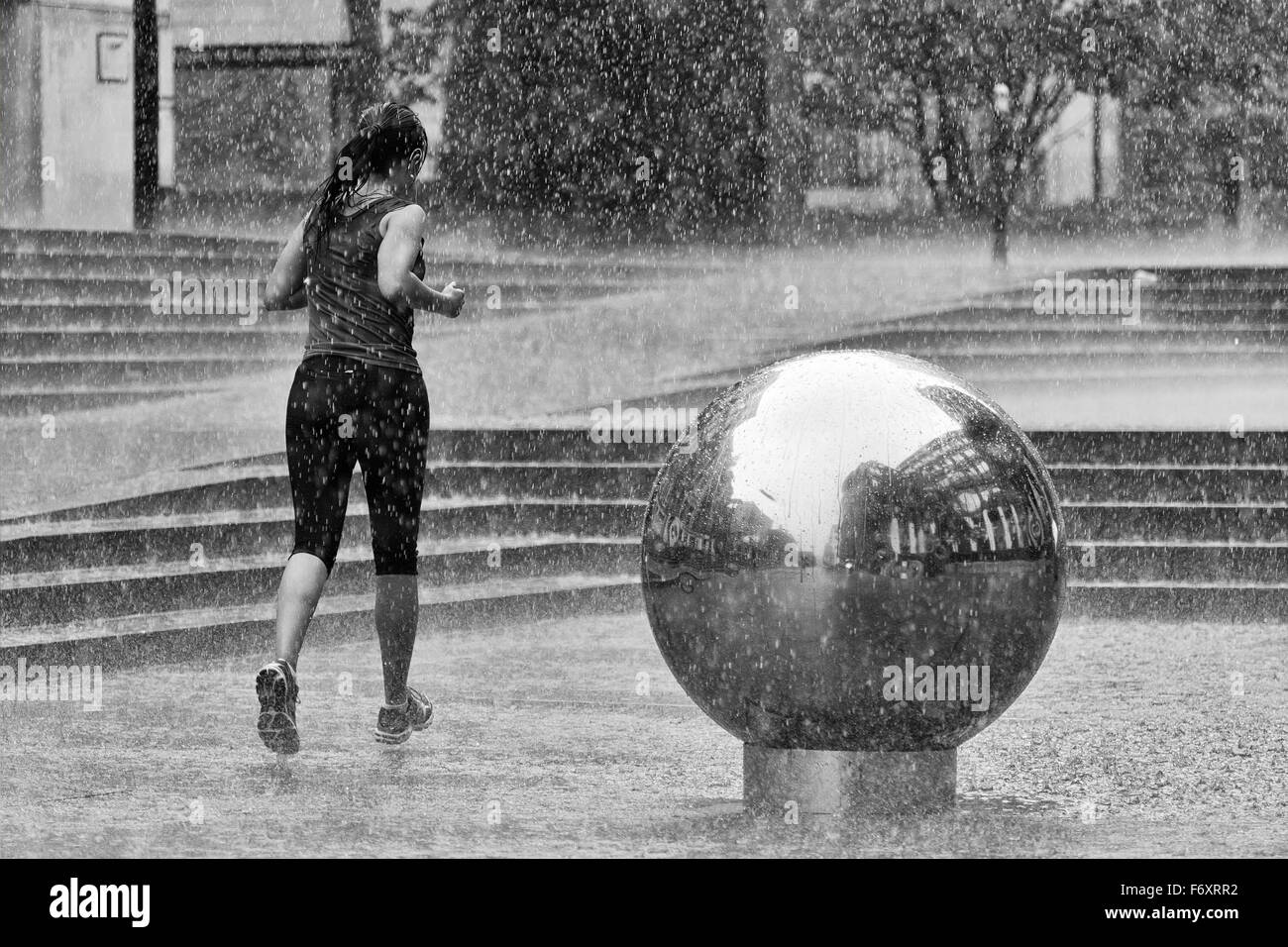 Eine weibliche Jogger an einem regnerischen Nachmittag in London Stockfoto