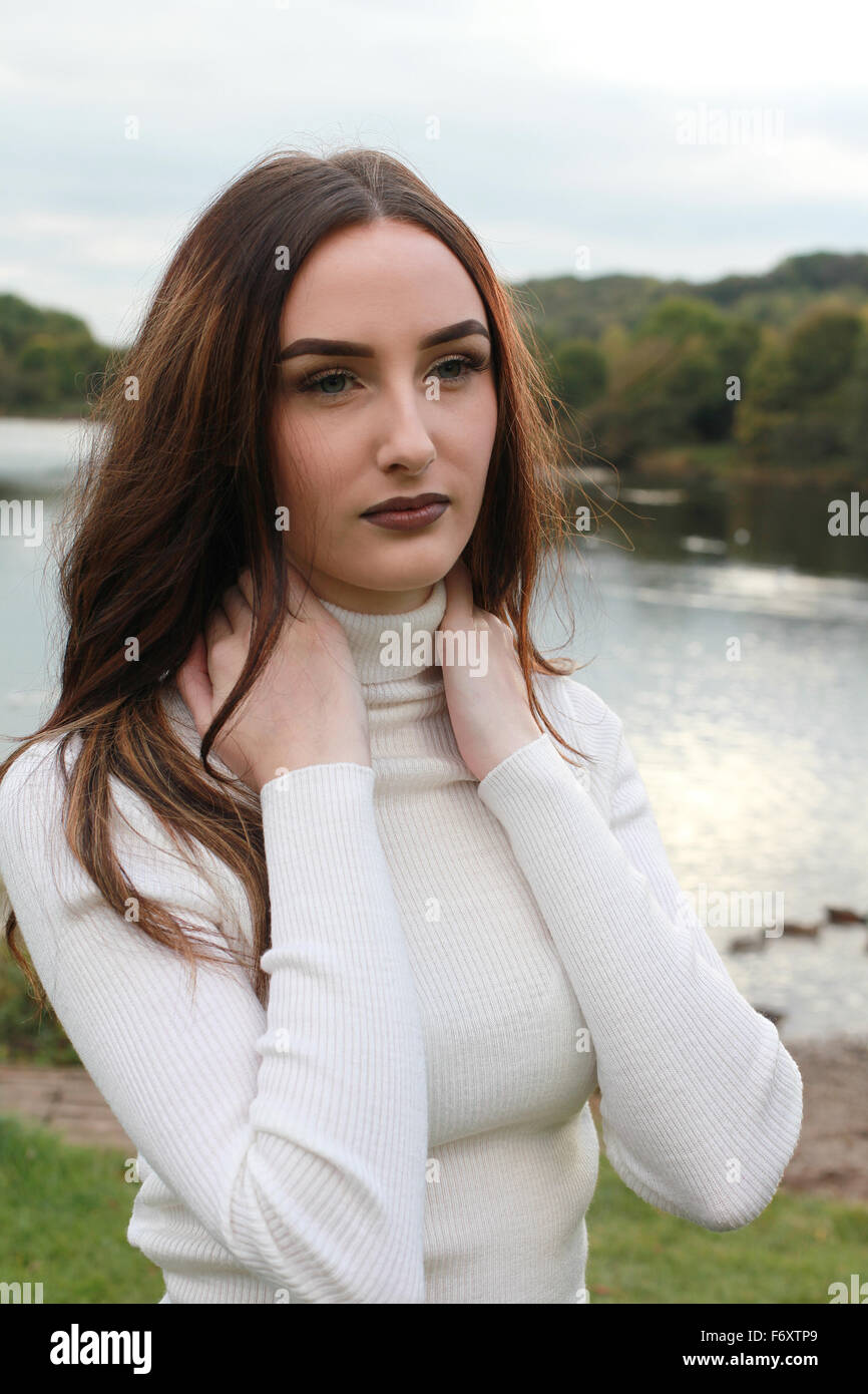 Schöne junge Frau trägt lässige Outfit im Freien mit See im Hintergrund Stockfoto