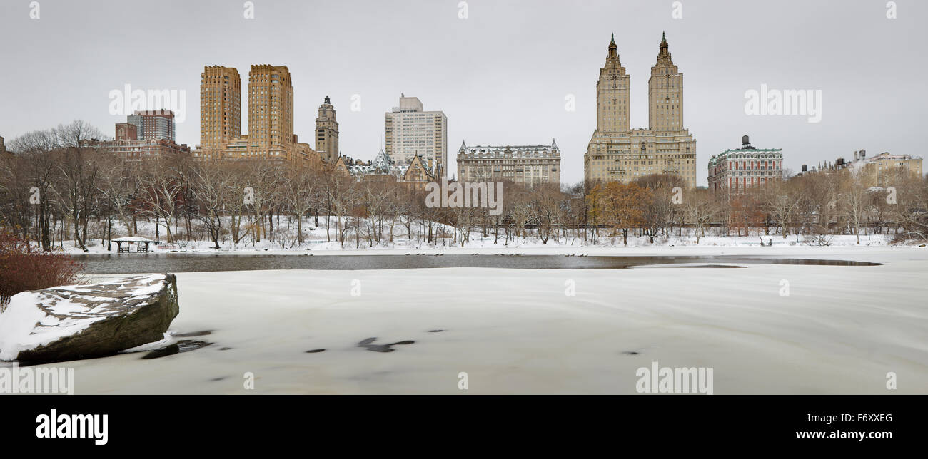 Wintermorgen nach Schneefall im Central Park und den zugefrorenen See. Manhattan Upper West Gebäude erheben sich über den Park, New York City Stockfoto