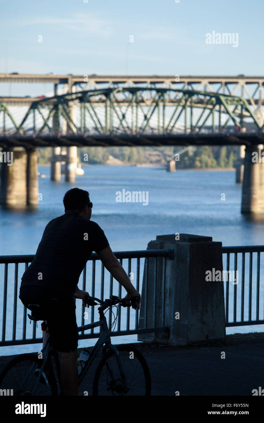 Ein Radfahrer Fahrrad entlang der Uferpromenade in Portland, Oregon. Stockfoto