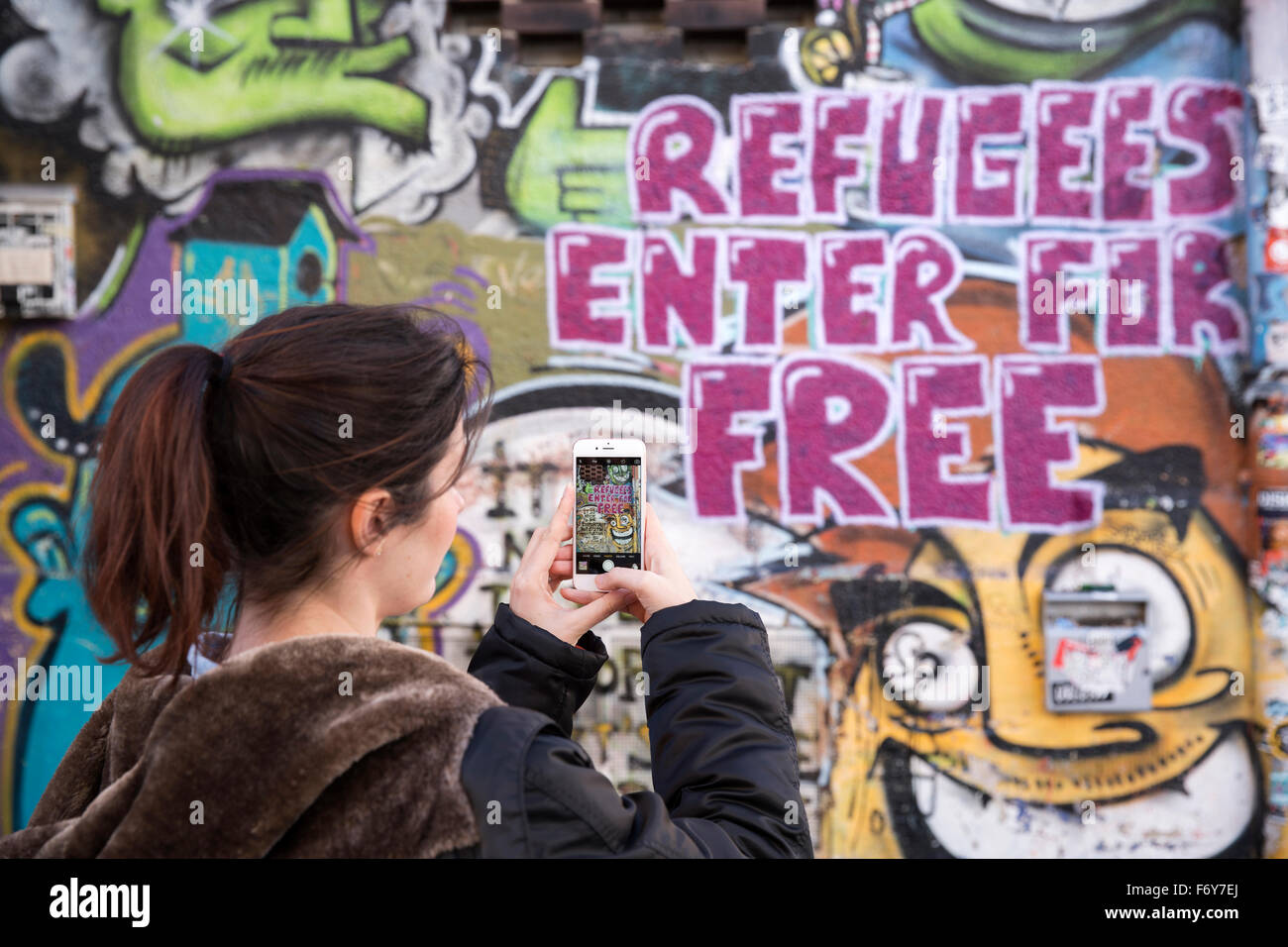 Frau, die ein Foto von Graffiti an der Wand eines Hostels in Deutschland Stockfoto