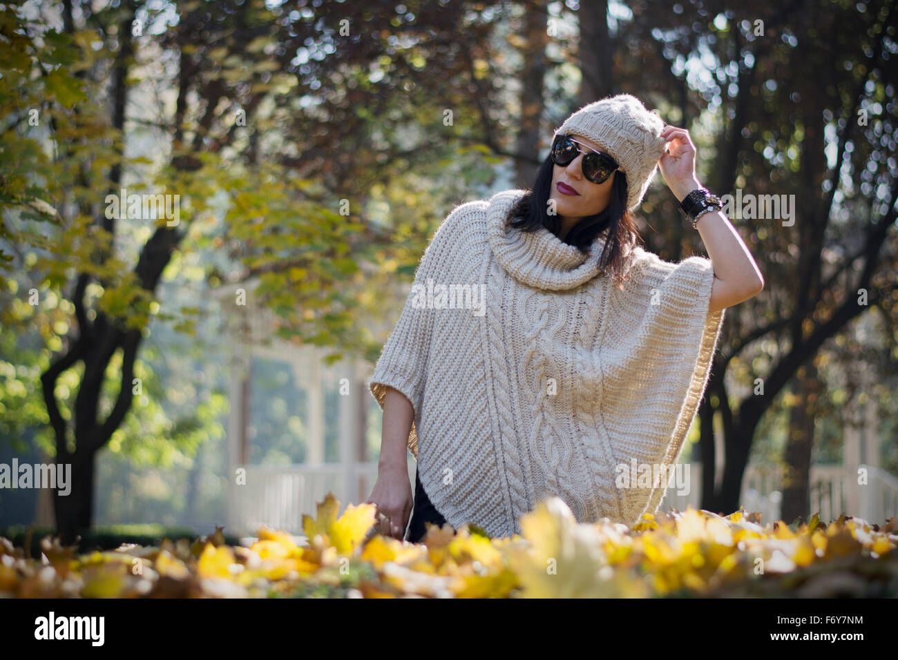 Schöne und attraktive schwarze dunkelhaarige Frau posiert für ein Mode-Shooting im Park im Herbst Stockfoto
