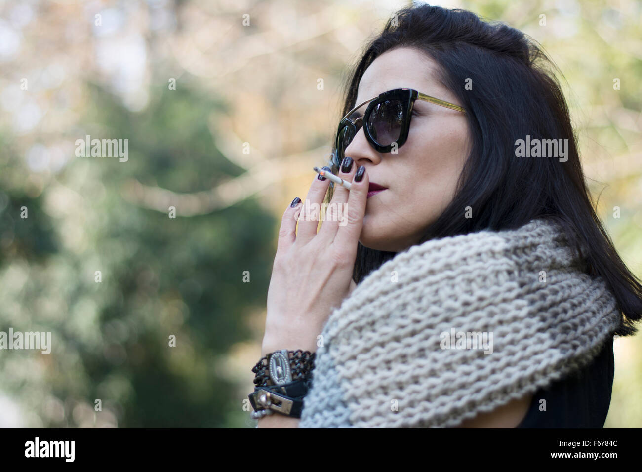 Attraktive schwarze Haare Frau genießen qualmender Zigarette im park Stockfoto